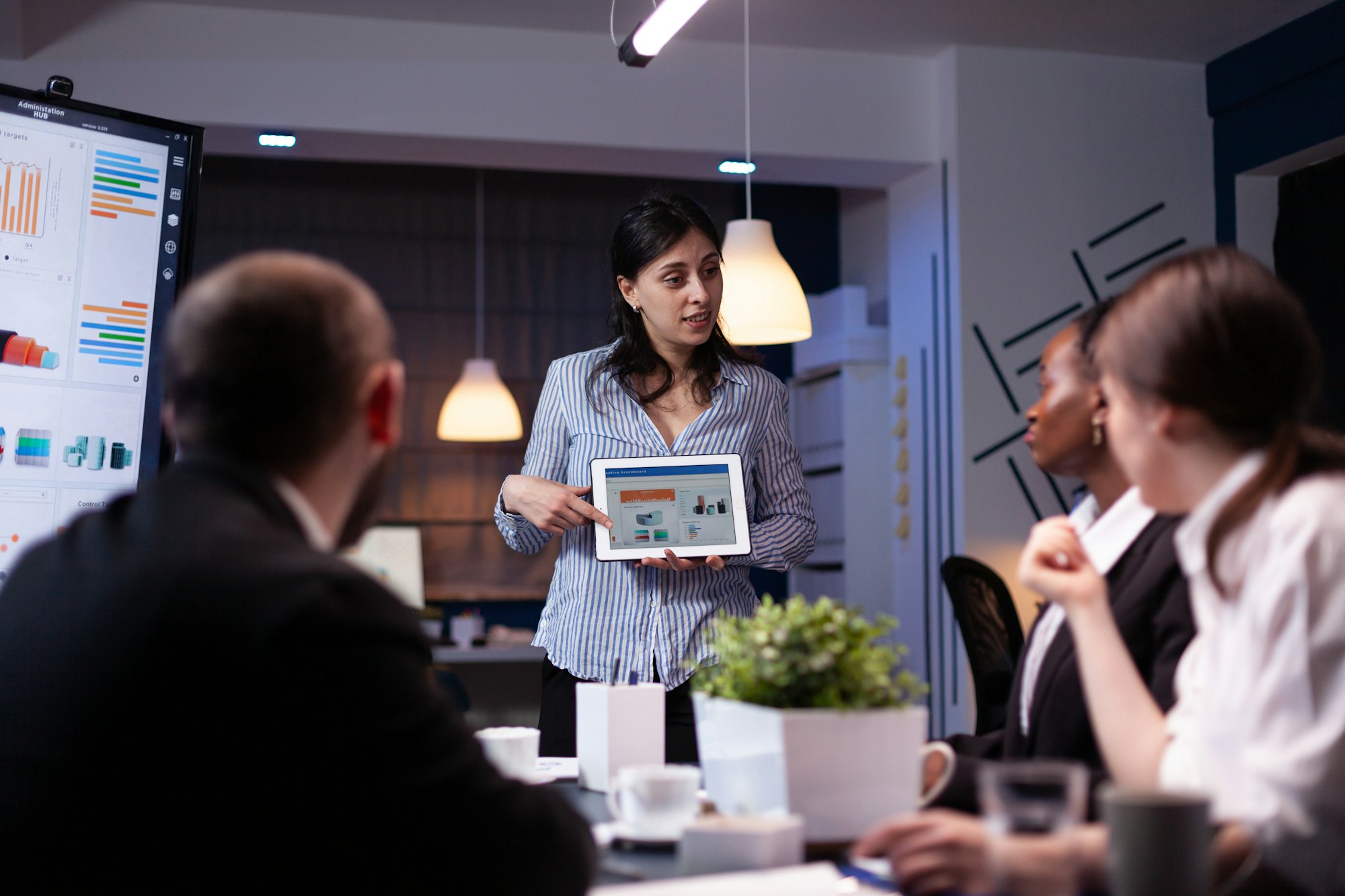 Manager holding tablet pc in meeting room late at night